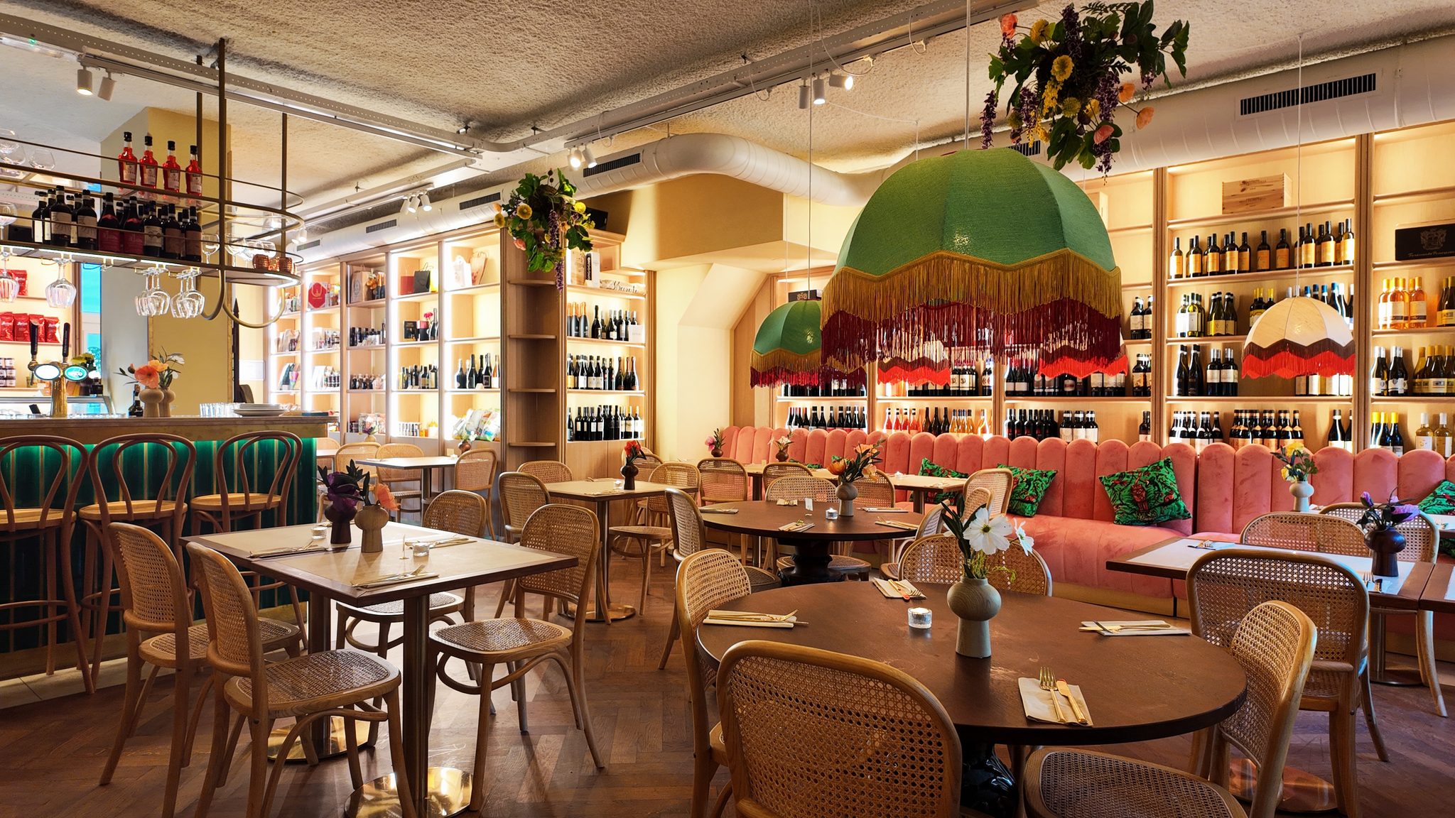 De osteria van Il Fico met ronde tafels, een groene lamp met franjes en wandkasten vol wijn