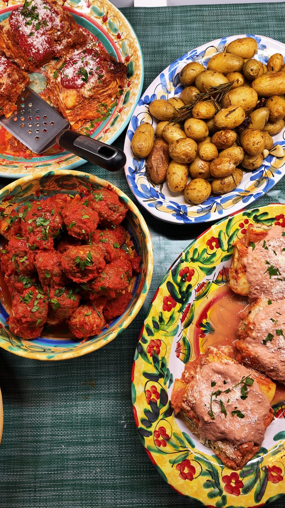 Polpette in tomatensaus, geroosterde aardappeltjes en lasagne op Italiaanse schalen