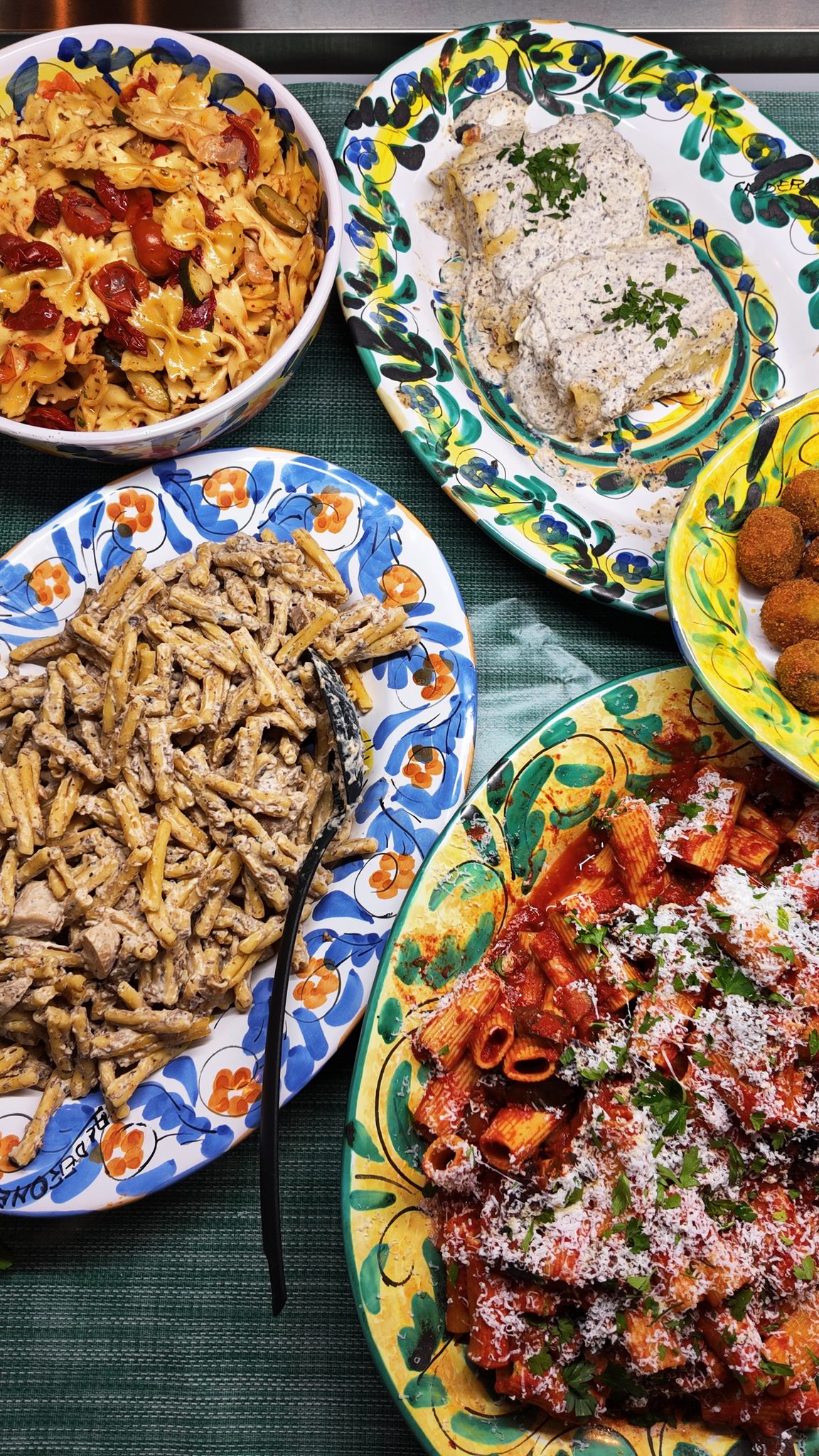 Verschillende pastagerechten op kleurrijke Italiaanse borden, vers uit de keuken van Il Fico
