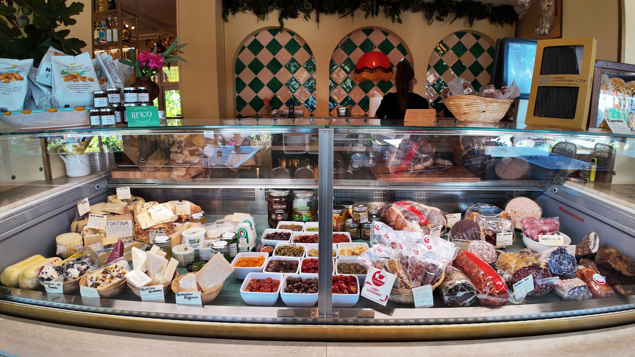 Vitrine vol Italiaanse kazen, vleeswaren en antipasti in de delicatessenwinkel van Il Fico
